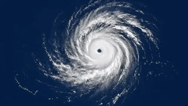 Illustration of a powerful typhoon with a small clear eye spiraling over a deep blue ocean near small islands