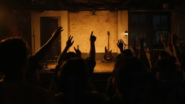 Illustration of a crowded small-town bar at night, hands raised toward a softly lit empty stage with a bass guitar on a stand